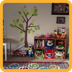 Shelve full of toys and tree art on a wall