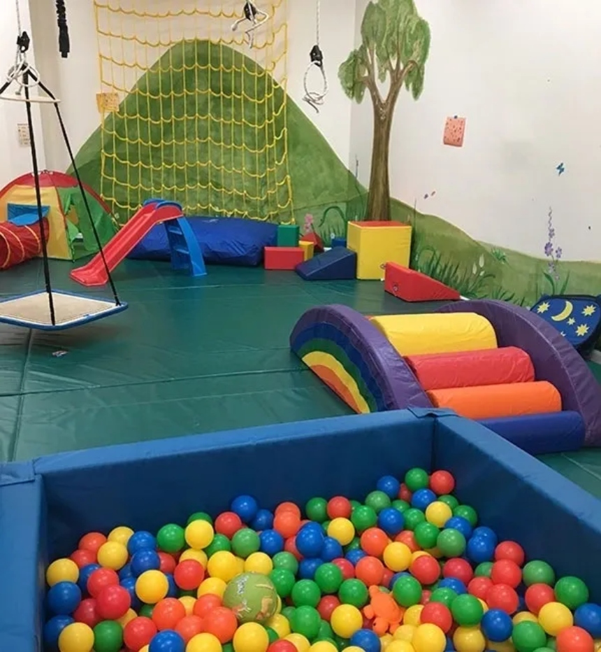 Children's playground with blue slides and colorful plastic balls in the pool.